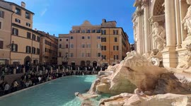 Overview of the Trevi Fountain and the square in front full of tourists on a bright February day in Rome.
