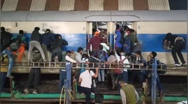 Frantic passengers climb through train windows in India