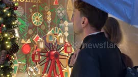 People look at one of the windows of a luxury shop on Via Condotti on a rainy day close to the Christmas period in Rome.