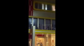 Crazed half-naked local leaps from hotel onto power lines like Superman