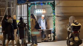A man sells roasted chestnuts along a downtown street on Christmas Eve in Rome.