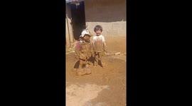 Mother amused by her two children covered in mud