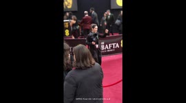 A young camerawoman girl dances happily while admiring her work at the 2025 EE BATFA Film Awards in London, UK