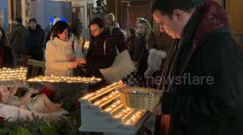 A priest collects the containers of spent candles from among those lit around the statue representing Baby Jesus that was displayed in the Parish Sanctuary of Santa Maria in Traspontina on Christmas Day in Rome.