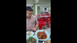 Cheeky pet cat reaches onto table to steal spicy fish