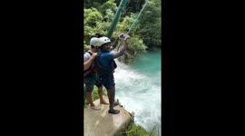 Tourist amuses his friends with his attempts at swinging into lagoon
