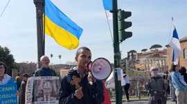 A protester holding an Orthodox Christian crucifix speaks about the persecution in Ukraine against Russian church priests and harshly criticizes Russian Patriarch Kirill for his support for the war during a sit-in to demonstrate against the “Putin regime”