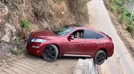 Driver's daring U-turn on narrow road leaves car teetering over steep edge
