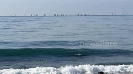 Numerous sailboats on the horizon off the coast of Lido di Ostia on a clear Sunday in February with calm seas and spring temperatures in Rome.
