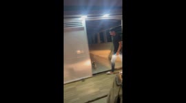 Man struggles to scare frog away from gate in Vista Serrana, Brazil