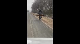 Cyclist transports large ammunition piece in Bryansk, Russia
