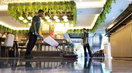 Man slips while employees clean floor in Yogyakarta, Indonesia
