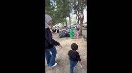 Person in frog costume teases child in Malacca, Malaysia