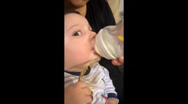 Baby enjoys meat while drinking milk in Baku, Azerbaijan