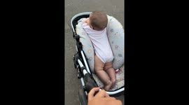 Baby rides stroller in an unusual way in Santa Fe, Argentina