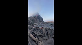 Traveler pokes molten lava as Erta Ale volcano erupts in Afar, Ethiopia