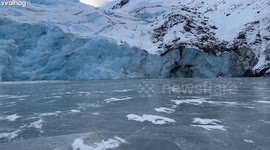 Glacier Breaks Onto Frozen Lake
