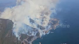 Helicopters drop water to battle wildfire in Japan