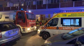 Emergency medical workers enter a building where there is only one person who has fallen ill and in the foreground the crane of the Fire Brigade and the ambulance with its flashing lights on in a peripheral area of Rome.