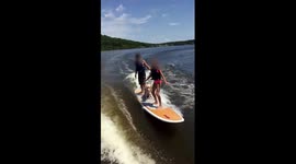 Dog surfs with two people on board