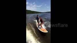 Dog surfs with two people on board