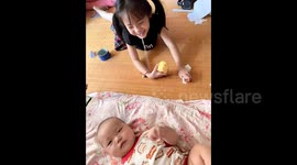 Nine-month-old baby helps pull out older sister's loose tooth