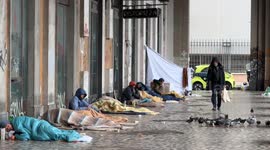 Coming and going of Roman citizens and tourists in front of the homeless who bivouac in the camp built under the porticoes overlooking Piazza dei Cinquecento, in front of Termini station in Rome.