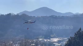Helicopter collects water to fight forest fire in Yamanashi, Japan