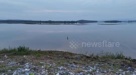 The Great Escape: a fish that has just been hooked, makes a successful last minute dash for freedom at Nam Un Dam, Thailand. (re-edit).