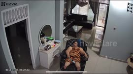 Cat falls on mom while she sits on a chair
