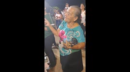 Elderly woman lives in the moment and dances happily at a festival