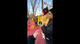Child throws hoop perfectly onto man's shoulders in Beijing