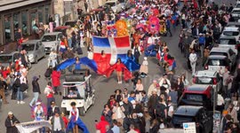 High angle shot of people from the Dominican Republic in traditional dress carrying a large Dominican flag during the procession to celebrate independence from the Government of Haiti and celebrate Carnival in Rome.