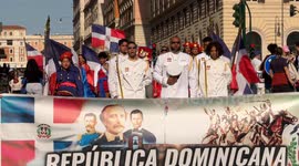 People from the Dominican Republic in traditional dress behind the banner with the words ‘Repùblica Dominicana, aniversario indipendencia nacional’ before starting the procession to celebrate independence from the Government of Haiti and celebrate Carniva