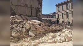 Firefighters search for woman trapped under collapsed building in Italy