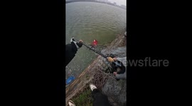 Quick-thinking man uses fishing rod to rescue woman from freezing river in China