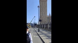 A barefoot protestor holding a Palestinian flag climbs the Elizabeth Tower (also known as Big Ben) in London