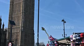 A protestor holding a Palestinian flag climbs the Elizabeth Tower in London, UK