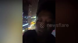 Trapped residents climb out of burning apartment's window to escape fire