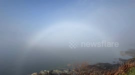 A rare fog bow as the morning mist rolls in over Loch Long in Argyll Scotland