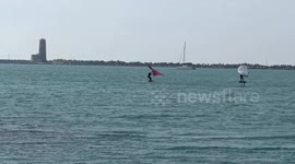 People practice wing foil in the stretch of sea near the old lighthouse where the construction of the cruise tourist port is planned in Fiumicino near Rome .
