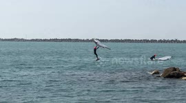 People practice wing foil in the stretch of sea near the old lighthouse where the construction of the cruise tourist port is planned in Fiumicino near Rome .