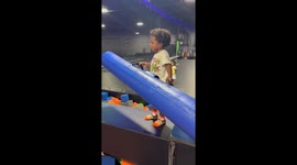 Little girl falls into foam pit while playing 'Battle Beam' with dad