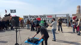 People demonstrate in the area in front of the old lighthouse following the construction of a fence that limits access to the beach in front of the historic fishing platforms, in Fiumicino near Rome.
