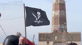 People demonstrate in the area in front of the old lighthouse following the construction of a fence that limits access to the beach in front of the historic fishing platforms, in Fiumicino near Rome.
