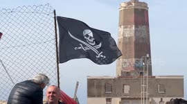 People demonstrate in the area in front of the old lighthouse following the construction of a fence that limits access to the beach in front of the historic fishing platforms, in Fiumicino near Rome.