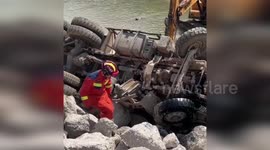 China: Concrete Mixer Truck Flips into River, Firefighters Wade in to Save Trapped Driver
