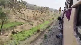 Passenger hangs from moving train window in failed stunt