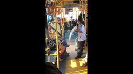 Caring bus conductor fans mother and child on sweltering ride in Bangkok