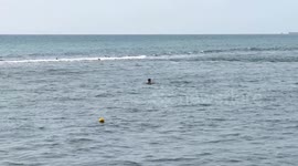 A tourist bathes in the sea at Lido di Ostia on a warm March day in Rome.